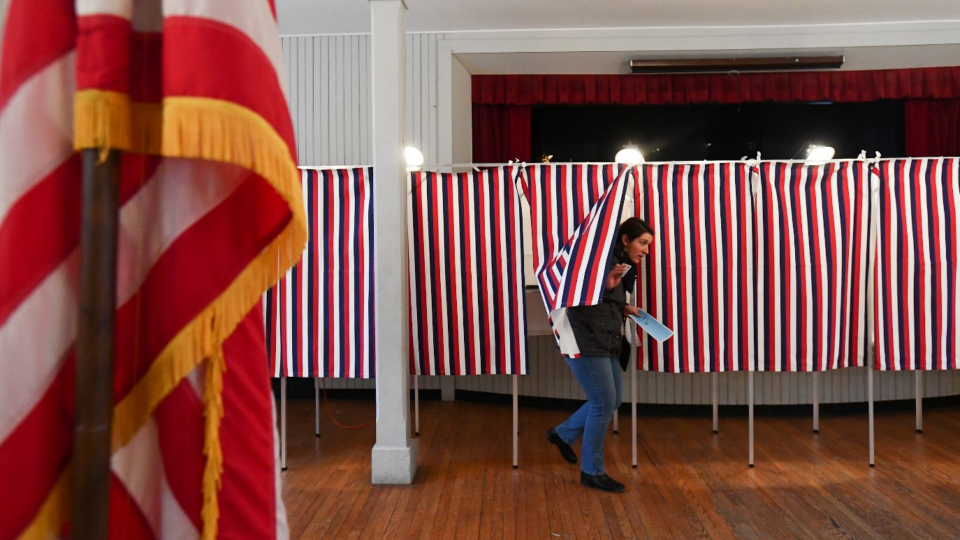 A voter leaves a voting booth after casting her ballot in the presidential primary election in Greenfield, New Hampshire