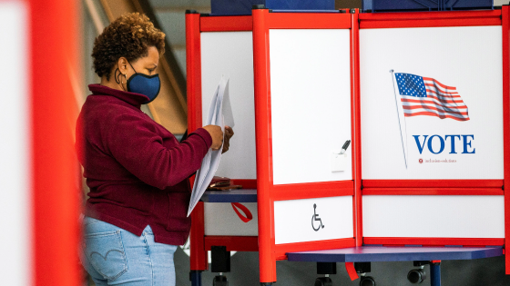 A woman fills her ballot in a privacy booth while voting in the gubernatorial election in Newark