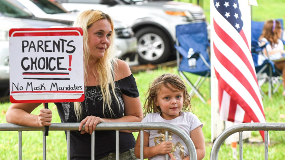 A woman holds a placard outside a meeting of the Volusia County School Board in Deland