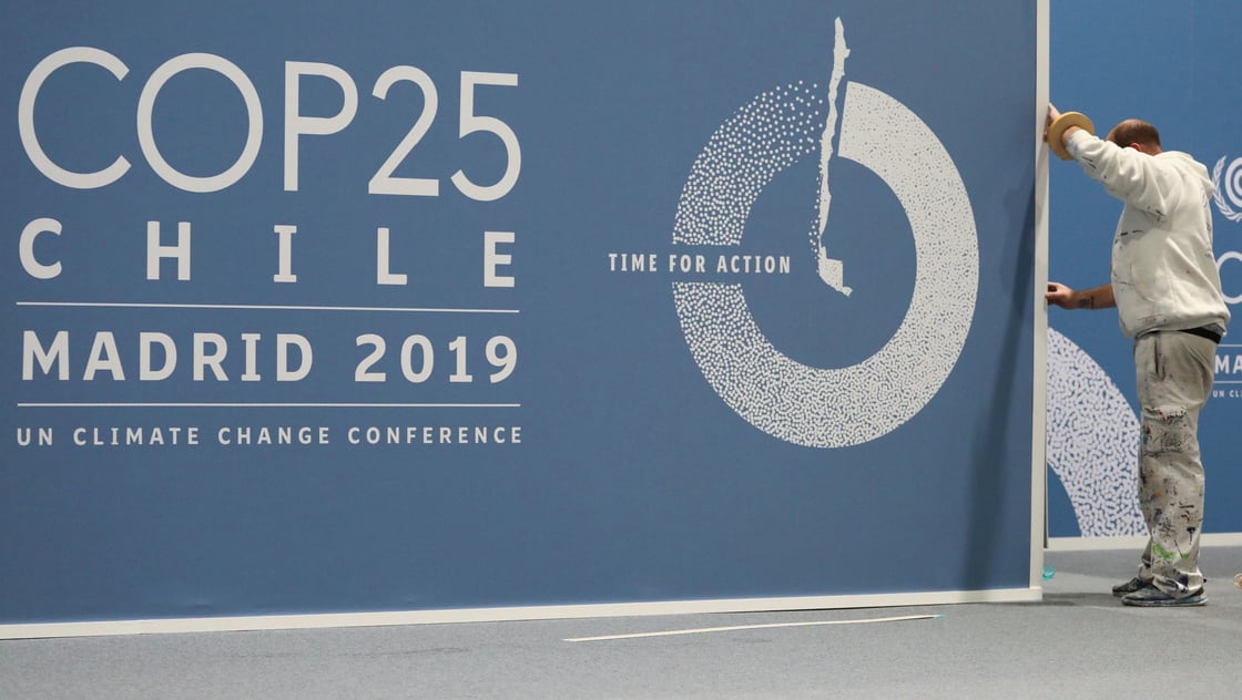 A worker adjusts a banner at IFEMA Convention Center ahead of the 2019 U.N. climate change conference