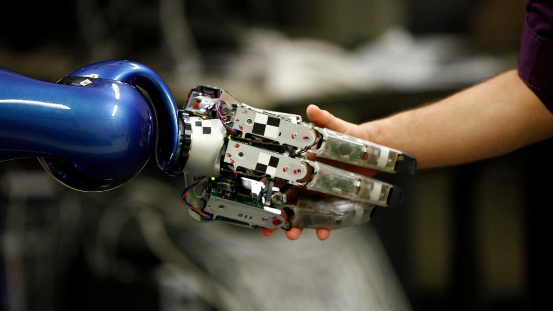 Alexander Dietrich of the German air and space agency shakes the hand of the humanoid two arm system robot Justin during a presentation in Oberpfaffenhofen near Munich