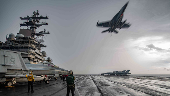 An FA-18E Super Hornet flies over the flight deck of the USS Ronald Reagan