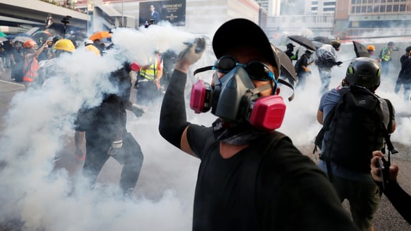 An anti-government protester throws back a tear gas canister at the police during a demonstration near Central Government Complex in Hong Kong-1