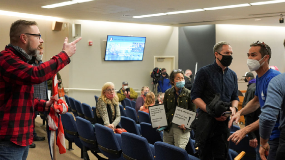 An anti-vaccine mandate protester argues with another meeting attendee during an event organised by Portland Public School