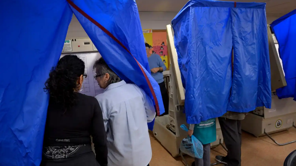 An election worker helps a voter use the voting machine during the U.S. presidential election in Philadelphia