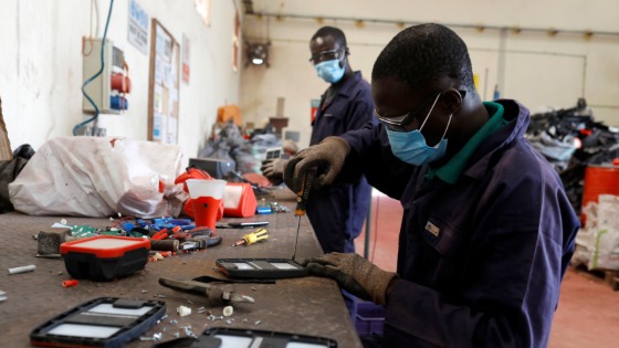 An employee dismantles old solar panels