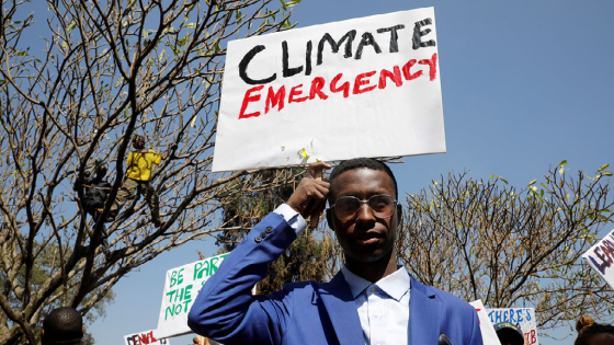 An environmental activist holds a sign as he takes part in a protest calling for action on climate change in Nairobi