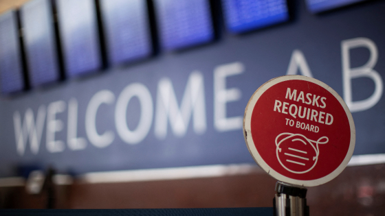 An outdated sign requiring Delta Air Lines passengers to wear a face mask to board a plane