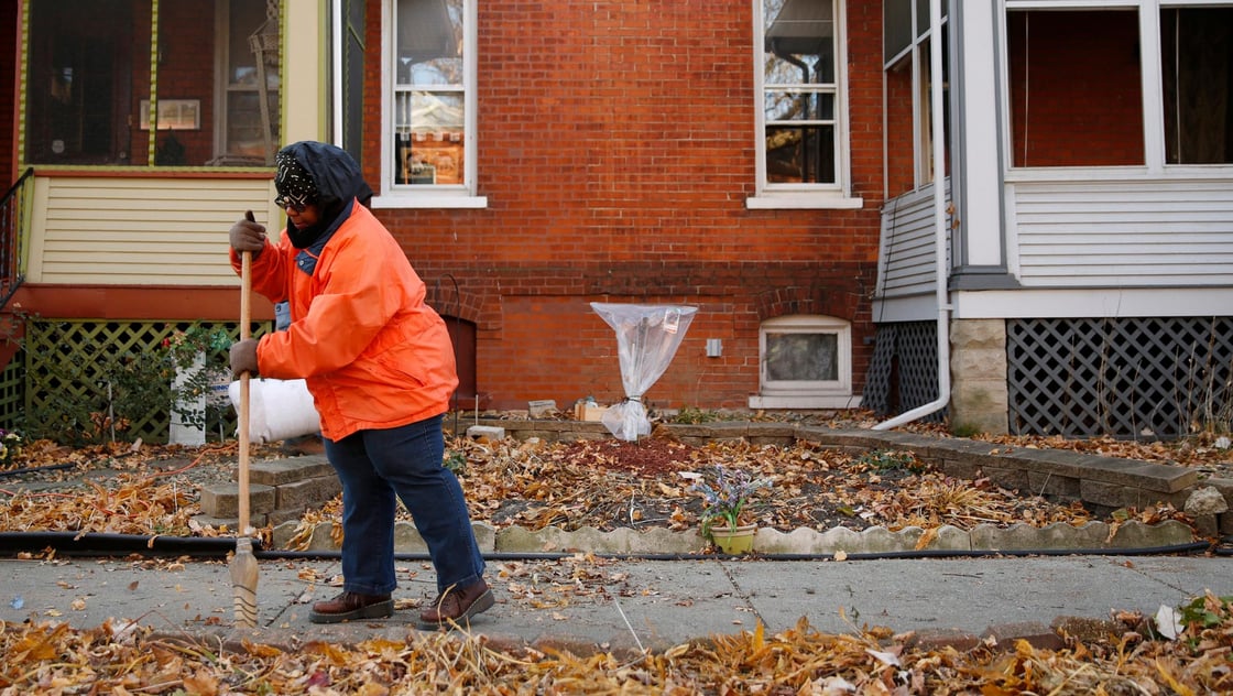 Ardana McFerren sweeps leafs outside of her home in the historic Pullman neighborhood in Chicago