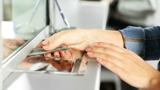 Bank employee hands cash to customer