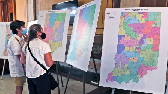 Benjamin Rascon Gracia and Jane Ramirez look at old district maps in the lobby outside the House Chambers after a legislative redistricting hearing