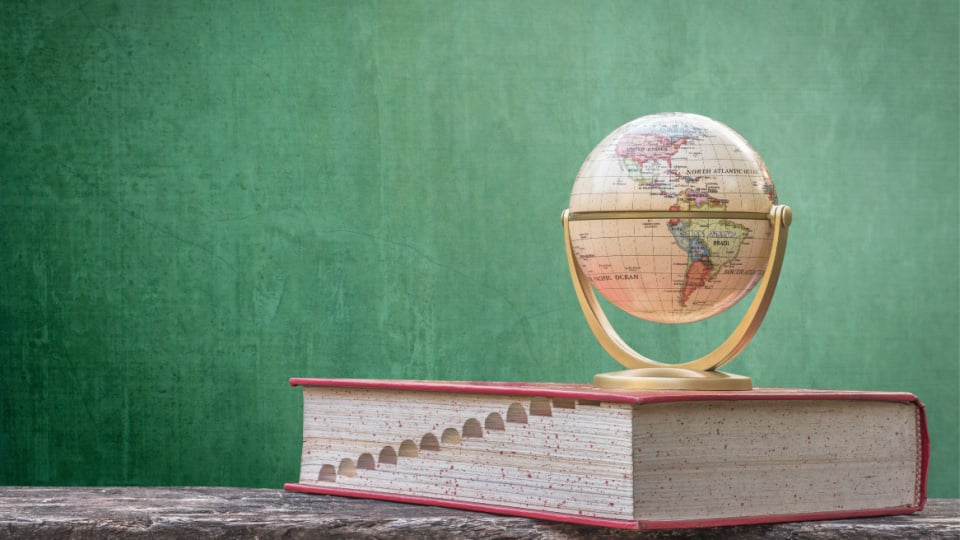 Book with a globe on top of it.