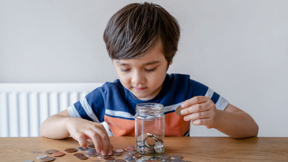 Boy putting change in a jar