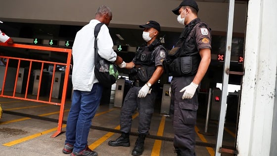 Brazil police officers wearing protective face masks check a ferry passengers documents