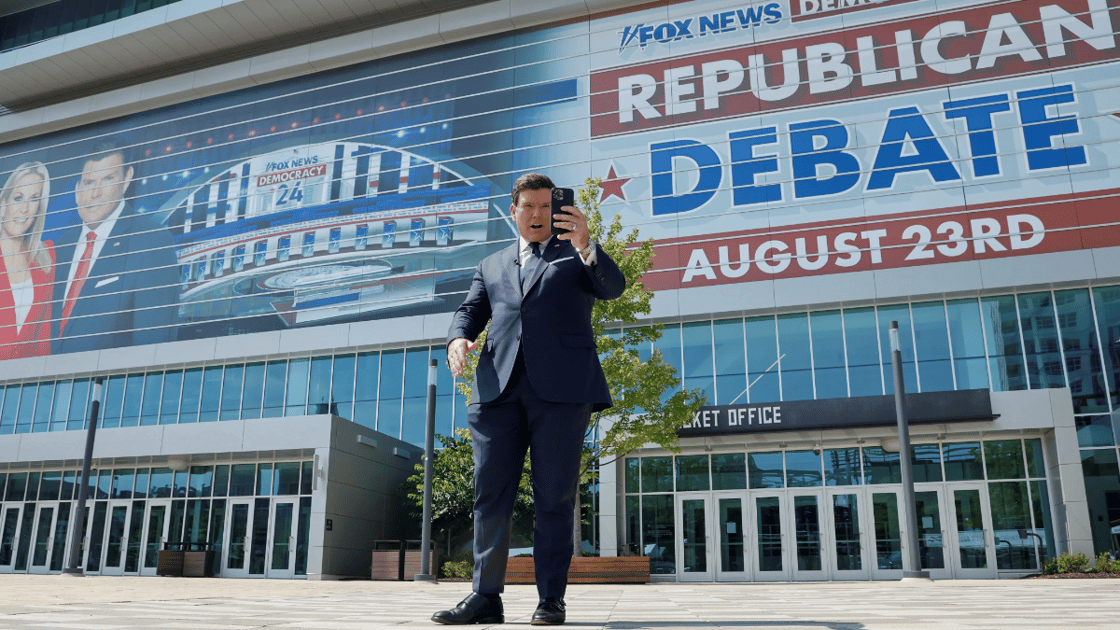 Bret Baier of Fox News stands outside of the arena hosting the first presidential debate of 2023