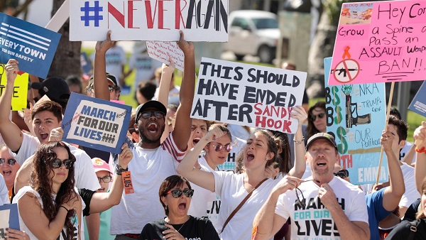 Students hold signs while rallying in the street during the “March for Our Lives”