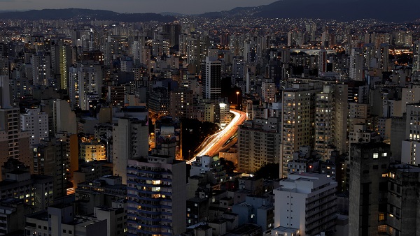 A general view shows buildings and cars driving down a main avenue in downtown Sao Paulo.