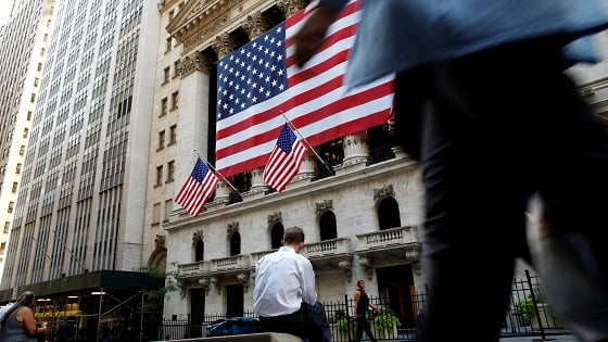 People sit outside the New York Stock Exchange (NYSE) during the morning commute in New York City