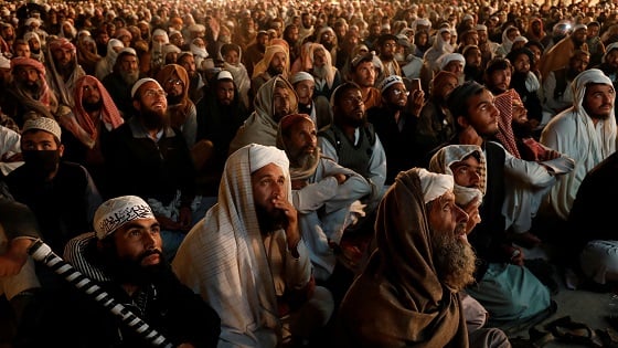 Supporters of the Jamiat Ulema-e-Islam - Fazal (JUI-F), watch speeches of their leaders on a large video screen.