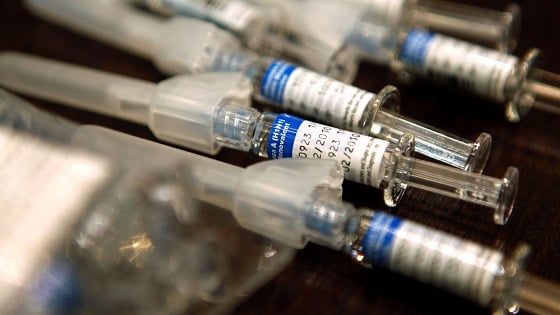 Syringes filled with the H1N1 flu vaccine are seen on a table at a nurses station.