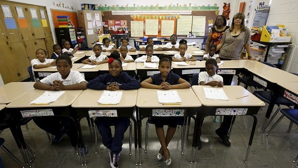 Teachers pose for a picture with their third grade class in Chicago, Illinois.