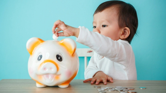 Child putting money in a piggy bank