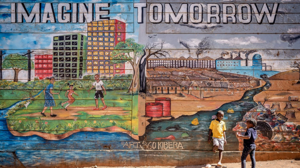 Children stand in front of mural saying IMAGINE TOMORROW