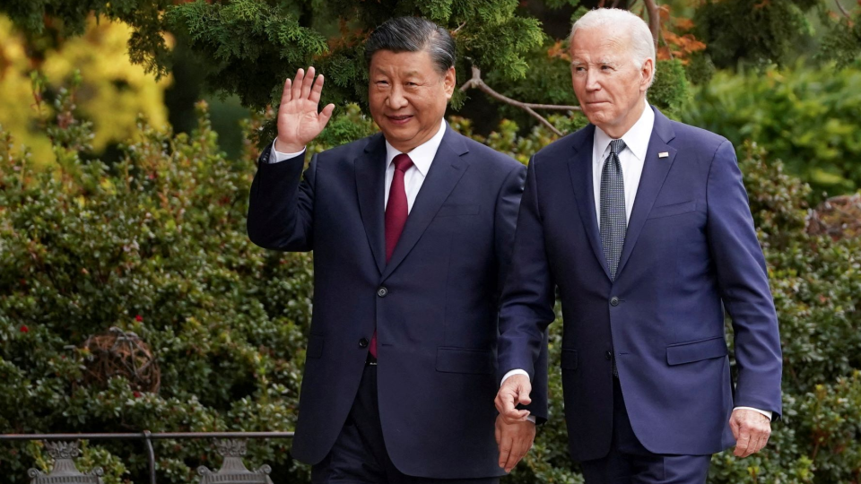 Chinese President Xi Jinping and U.S. President Biden walk alongside one another.