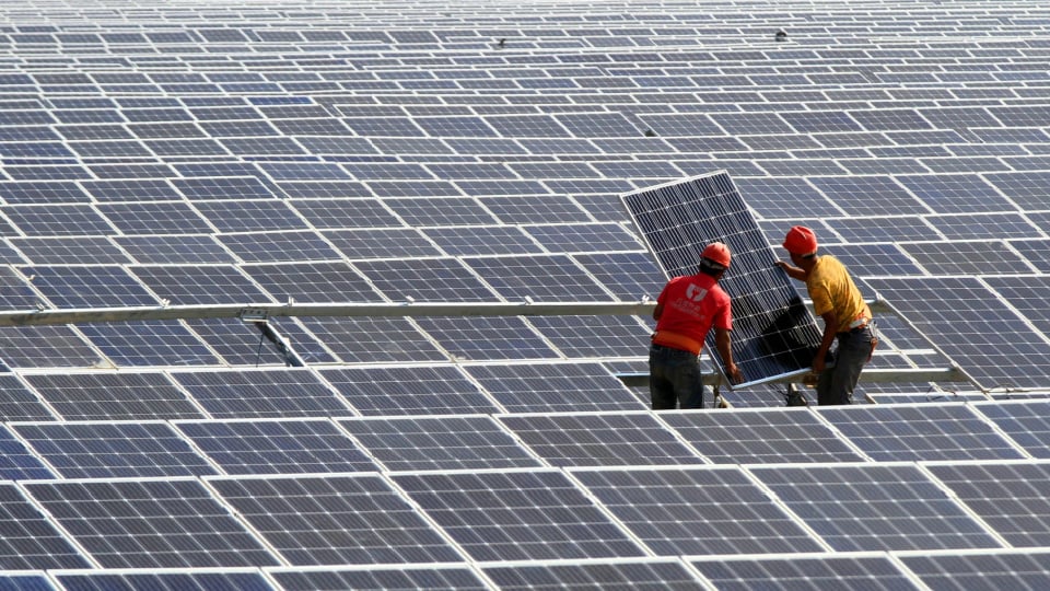 Chinese workers install solar panels at a photovoltaic power station in Huaian city.