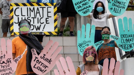 Climate activists hold up signs