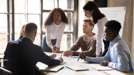 Co-workers collaborate on a project at a table.