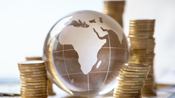 Coins piled around a globe featuring Africa