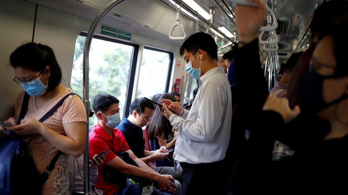 Commuters wearing masks in precaution of the coronavirus outbreak are pictured in a train during their morning commute in Singapore
