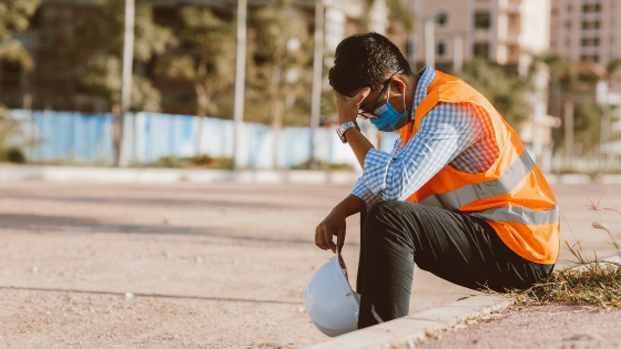 Construction worker sitting on curb