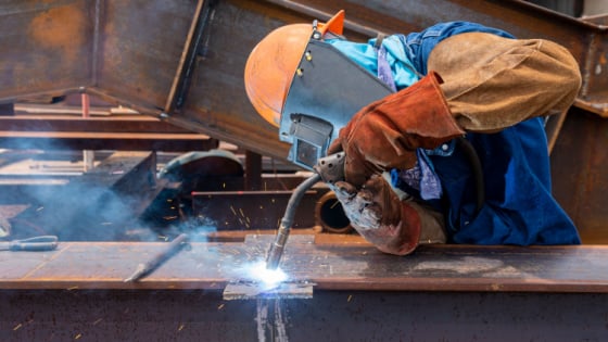 Construction worker welding on job site.