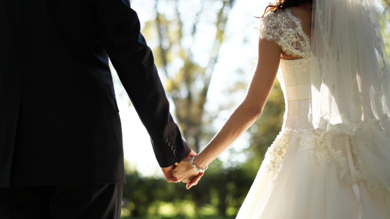 Couple holds hands at their wedding