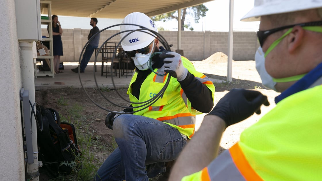 Cox communications employees install internet wires