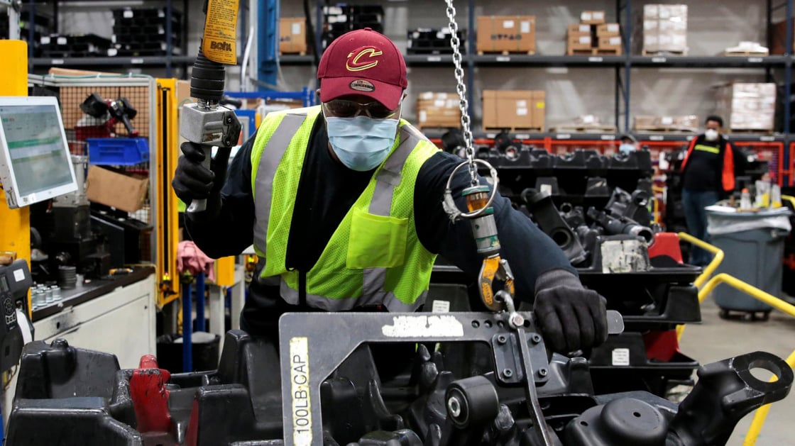 Dana Inc assembly technician Brandon Green wears a face mask as he works to assemble axles for automakers