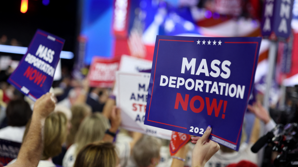 Delegates hold signs that read "Mass deportation now" on Day 3 of the Republican National Convention (RNC)