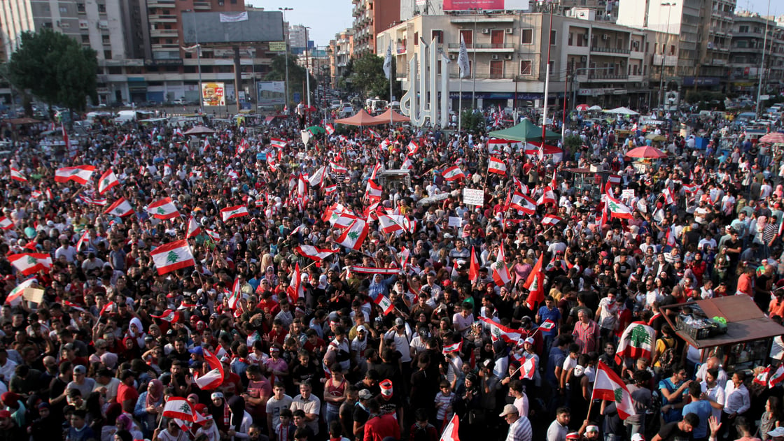 Demonstrators carry national flags during an anti-government protest in Tripoli