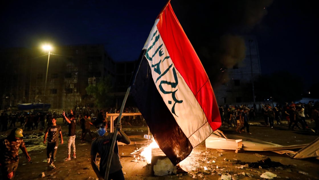 Demonstrators gather at a protest during a curfew, two days after the nationwide anti-government protests turned violent, in Baghdad