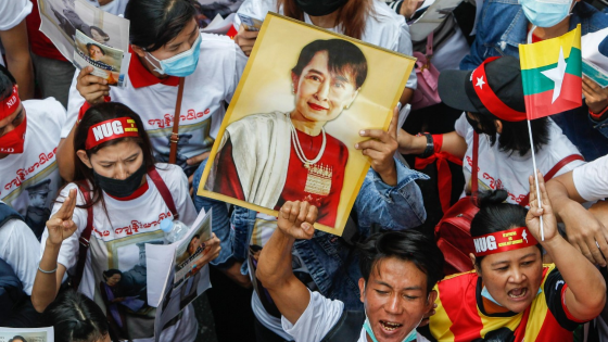 Demonstrators hold a portrait of pro-democracy icon Aung San Suu Ky and raise their three finger salute during a rally