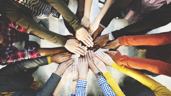 Diverse group of people holding out their hands