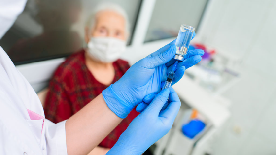 Doctor preparing a vaccine dose for an elderly patient