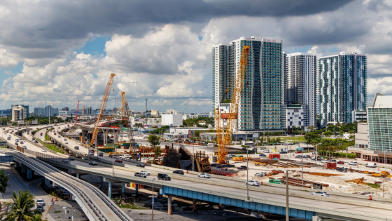 Downtown overlooking highway construction traffic, buildings, and cranes on 395 MacArthur Causeway in Florida