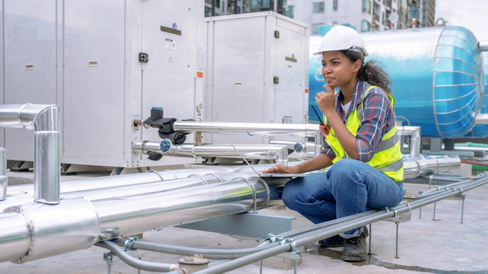 Engineer inspects the cooling system of a large factory air conditioner