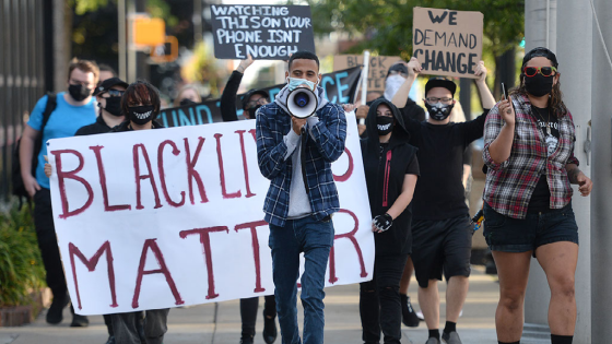 Erie Equal founder Andrey Rosado, center, leads protesters as they march past Erie City Hall