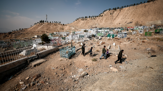 Family leaves the cemetery after praying by the graves of their family members