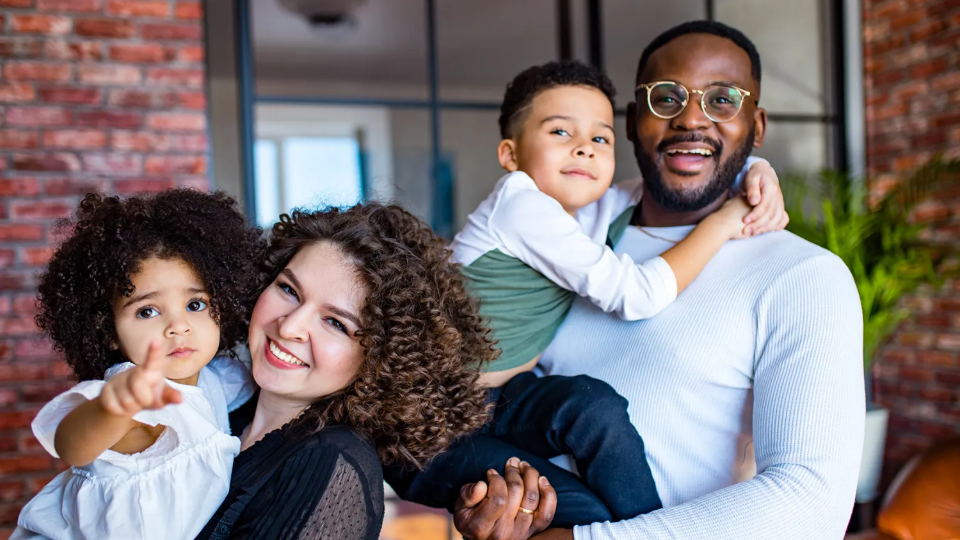 Family poses for camera outside of a building