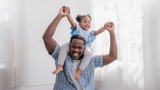 Father carries daughter on his shoulders